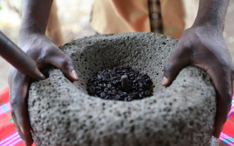 grinding-beans-old-fashioned-way-lake-duluti-lodge